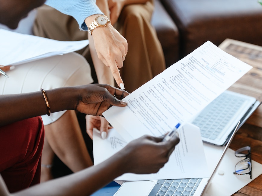 People reviewing printed documents, one page held at an angle
